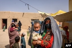 Una mujer que huyó de su aldea en Helmand cuando fue tomada por los talibanes, espera ver a un médico en una clínica móvil para mujeres y niños instalada cerca de Lashkar Gah en la provincia de Helmand, Afganistán, el 28 de marzo de 2021.