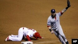 Boston Red Sox first baseman Mike Napoli celebrates after tagging out St. Louis Cardinals' Kolten Wong on a pick-off attempt to end Game 4 of baseball's World Series, Oct. 27, 2013.