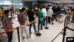 A handout picture released by the Colombian Presidency press office shows migrants deported from the United States lining up at the immigration counter at El Dorado International airport in Bogota, Colombia, Jan. 28, 2025. (Colombia Presidency press office via AFP)
