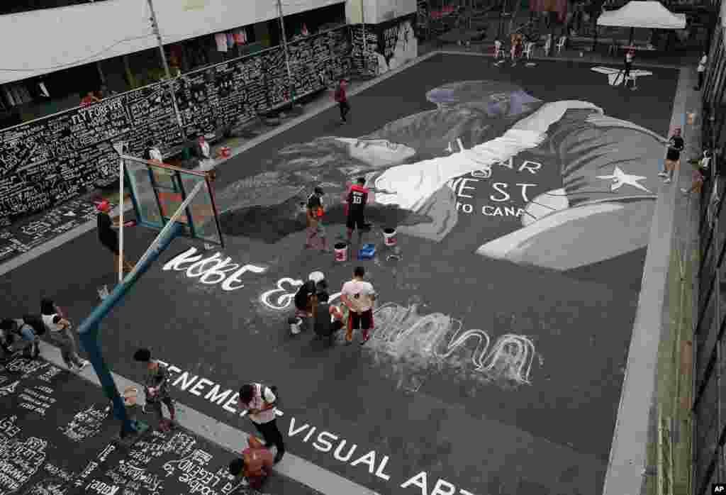 Artists put the finishing touches on a giant mural of former NBA basketball player Kobe Bryant and daughter Gianna, at a basketball court in Taguig, south of Manila, Philippines.