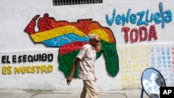 Un hombre camina frente a un mural de Venezuela con el territorio de Esequibo incluido en Caracas, el 29 de noviembre de 2023.