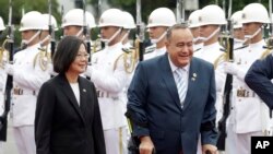 El presidente de Guatemala, Alejandro Giammattei (derecha), acompaña a su homóloga de Taiwán, Tsai Ing-wen, pasando revista a una guardia militar frente a la oficina presidencial en Taipéi, Taiwán, el 25 de abril de 2023.