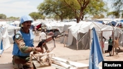 FILE - A United Nations peacekeeper keeps guard outside the Bor camp for the internally displaced in Bor town Jonglei state, South Sudan, Apr. 29, 2014. 