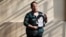 In this Sept. 6, 2018 photo, 54-year-old teacher Vittoria E Natto poses for a portrait inside her high school holding a photo of herself when she was 9 years old, in Santiago, Chile.