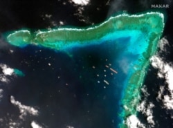 This satellite image provided by Maxar Technologies shows Chinese vessels at the Whitsun reef, in a disputed part of the South China Sea, March 23, 2021.