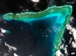 This satellite image provided by Maxar Technologies shows Chinese vessels at the Whitsun reef, in a disputed part of the South China Sea, March 23, 2021.
