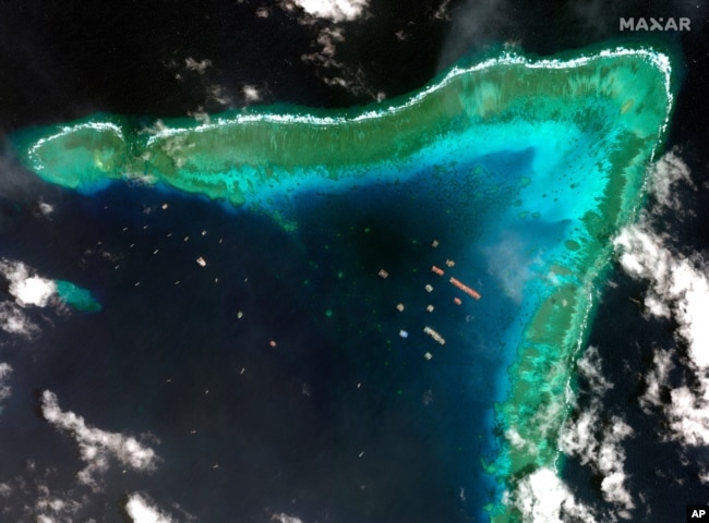 This satellite image provided by Maxar Technologies shows Chinese vessels at the Whitsun reef, in a disputed part of the South China Sea, March 23, 2021.