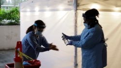 Nurses at a drive-up coronavirus testing station set up by the University of Washington Medical Center sanitize their hands after taking a nose swab sample from a person in a car Friday, March 13, 2020, in Seattle. UW Medicine is conducting drive…