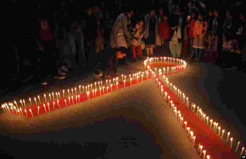 An Népal, des femmes et des enfants de &quot;Maiti Nepal&quot;, un centre de réadaptation pour les victimes de trafic sexuel, ont allumé des bougies à la veille de la Journée mondiale du sida à Katmandou, 30 novembre 2015.&nbsp;