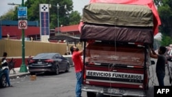 Trabajadores descargan un envío de ataudes en una funeraria ubicada frente al Hospital General de Ciudad de México.