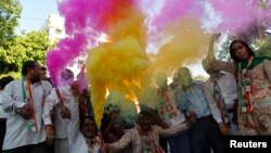 Supporters of India's ruling Congress party use color crackers during election celebrations outside party headquarters in Ahmedabad on May 8, 2013.