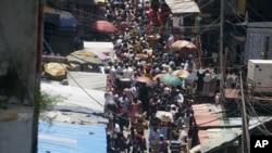 FILE - In this Thursday, Oct. 11, 2011 photo, people crowd a street in a market on Lagos Island in Lagos, Nigeria.