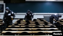 South Korean soldiers clean desks with disinfectant in a classroom for civil service exams, following the rise in confirmed cases of coronavirus disease (COVID-19) in Daegu, March 15, 2020.