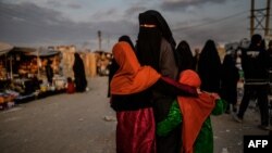 FILE - A veiled woman with children is seen at al-Hol camp in al-Hasakeh governorate in northeastern Syria, Feb. 17, 2019.