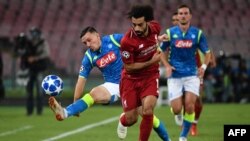 Mohamed Salah, pemain depan Liverpool (tengah) dan bek Napoli, Mario Rui (kiri), berebut menguasai bola dalam laga penyisihan Grup C Liga UEFA Champions antara Napoli vs Liverpool, 3 Oktober 2018.