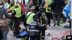 Petugas medis membantu orang-orang yang cedera di dekat garis finish Boston Marathon 2013, Copley Square, Senin, 15 April.