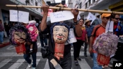 Manifestantes en Ciudad de Guatemala sostienen imágenes del presidente Jimmy Morales (centro), la canciller Sandra Jovel (izq.), y el ministro del Interior Enrique Dengenhart, el lunes 14 de enero de 2019. 