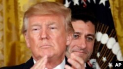 FILE - President Donald Trump applauds with House Speaker Paul Ryan of Wis., behind him in the East Room of the White House.