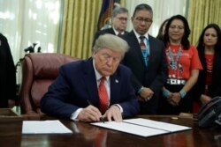 President Donald Trump signs an executive order establishing the Task Force on Missing and Murdered American Indians and Alaska Natives, in the Oval Office on Nov. 26, 2019, in Washington.