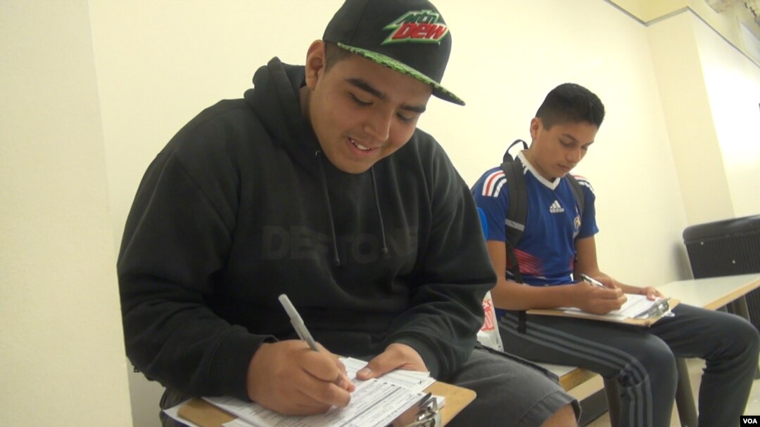 Two Hispanic men register to vote earlier this year in Houston. (G. Flakus/VOA)