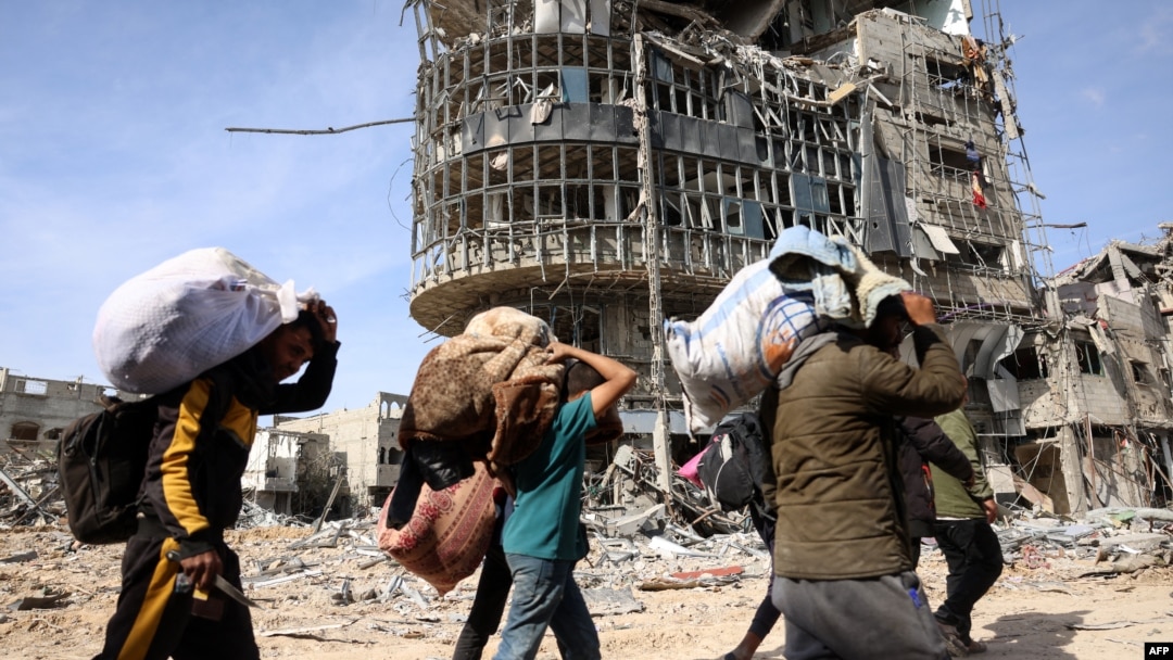 FILE - Displaced Palestinians carry their belongings as they walk amid the devastation upon their return to central Rafah in the southern Gaza Strip on Jan. 19, 2025, after a ceasefire between Israel and the Hamas movement took effect.