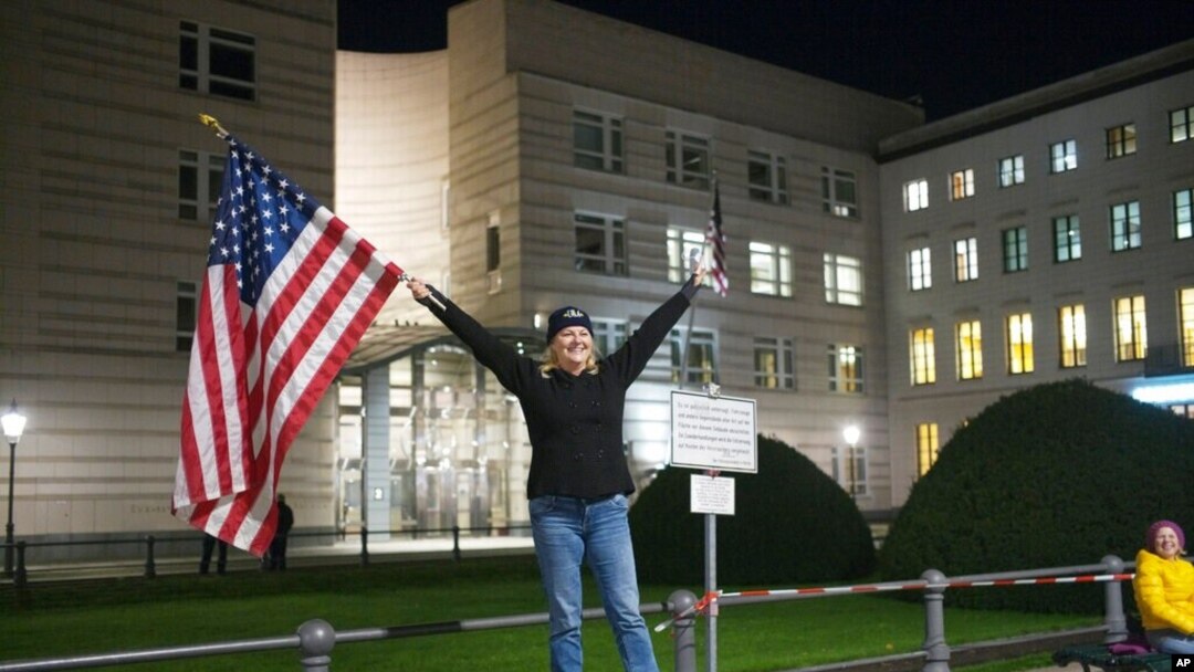 Marianne Hoenow from the U.S. state of Connecticut celebrates the victory of President-elect Joe Biden and Vice President-elect Kamala Harris in front of the U.S. Embassy next to the Brandenburg Gate in Berlin, Germany, Nov. 7, 2020. 