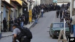 Policemen move inside the Complexo do Alemao slum during an operation against drug traffickers at in Rio de Janeiro, Brazil, 28 Nov 2010