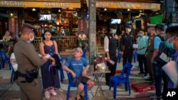 Petugas memberitahu pemilik bar untuk sementara tutup dalam upaya mencegah meluasnya perebakan virus corona di Khao San Road, Bangkok, Thailand, 18 Maret 2020. (Foto: dok).