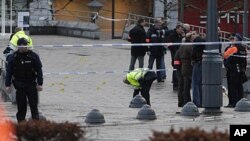 Police stand next to evidence markers after an incident in Liege, Belgium, December 13, 2011.