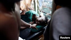 An injured man who medics say was shot by live fire during a protest of supporters of Kenyan opposition leader Raila Odinga is treated in a clinic in Kisumu, Kenya, Oct. 25, 2017.