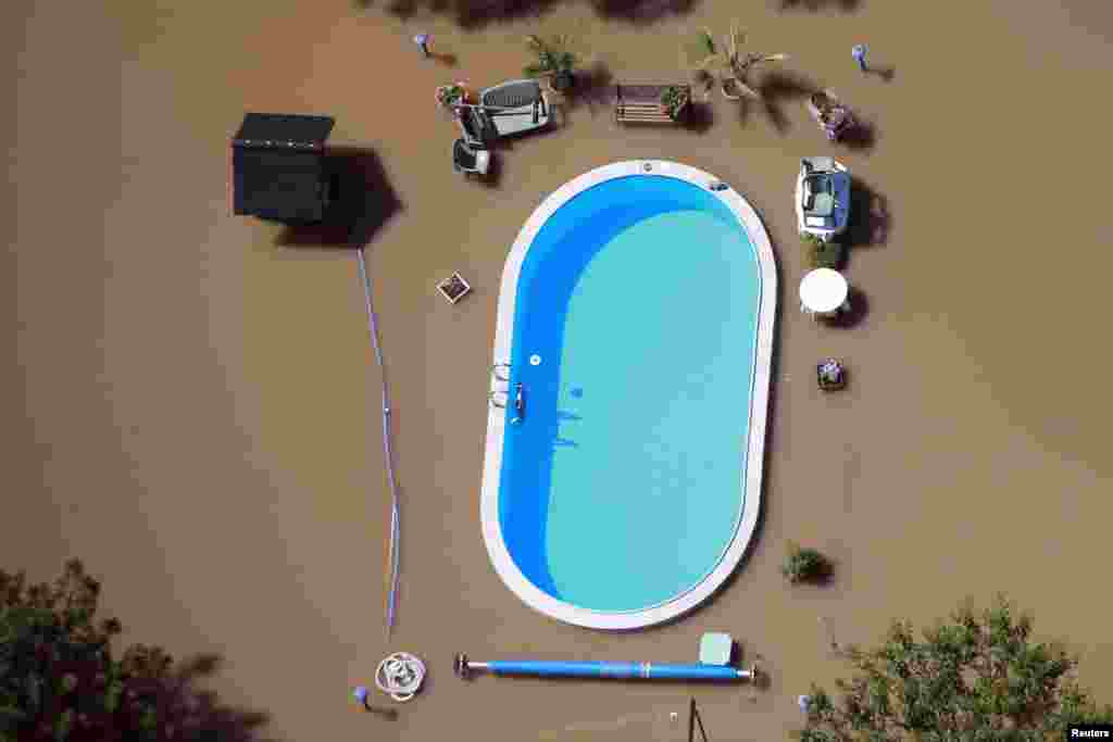 A garden with a swimming pool is inundated by the waters of the Elbe river during floods near Magdeburg in the federal state of Saxony Anhalt, Germany, June 10, 2013. Tens of thousands of Germans, Hungarians and Czechs were evacuated from their homes as soldiers raced to pile up sandbags to hold back rising waters in the region&#39;s worst floods in a decade.