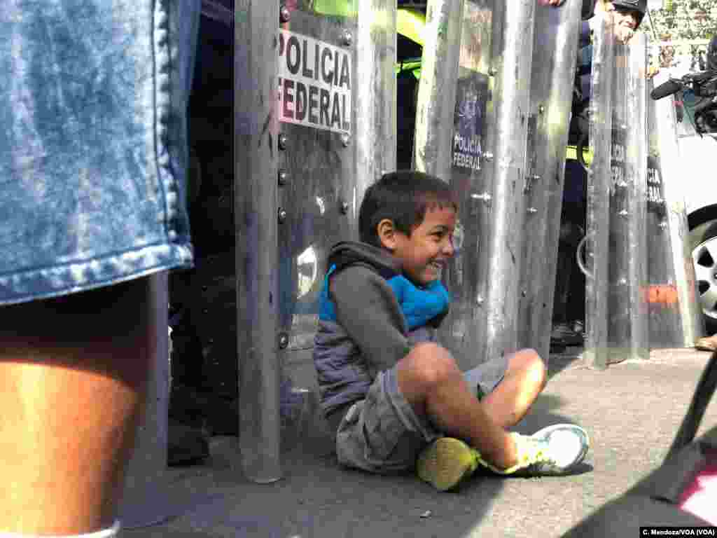 A little boy with the caravan sits in front of the Mexican federal police as the caravan arrived at a border crossing in Tijuana, Mexico, Nov. 22, 2018. Celia Mendoza/VOA