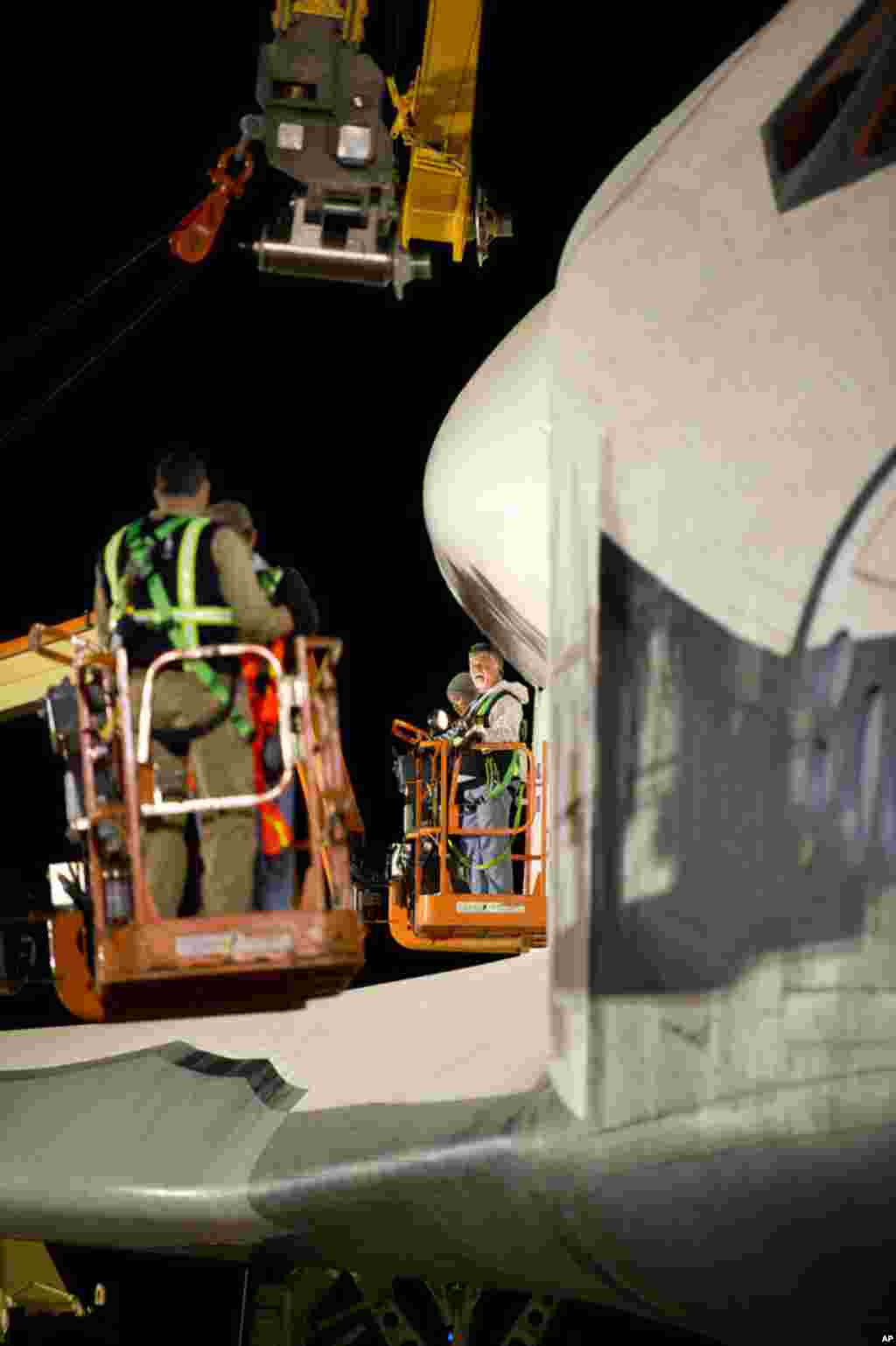 Workers prepare to attach the sling that will be used to lift Enterprise onto the NASA 747 Shuttle Carrier Aircraft at Washington Dulles International Airport, April 20, 2012, in Sterling, Virginia. (NASA/Bill Ingalls)