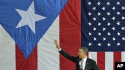 President Barack Obama waves to a crowd gathered inside a hangar at the Muniz Air National Guard Base, shortly after his arrival in San Juan, Puerto Rico, June 14, 2011