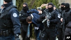 Kosovo police escort Marko Djuric a Serb official to a police station in Kosovo capital Pristina after he was arrested in northern Kosovo town of Mitrovica, Monday, March 26, 2018. 