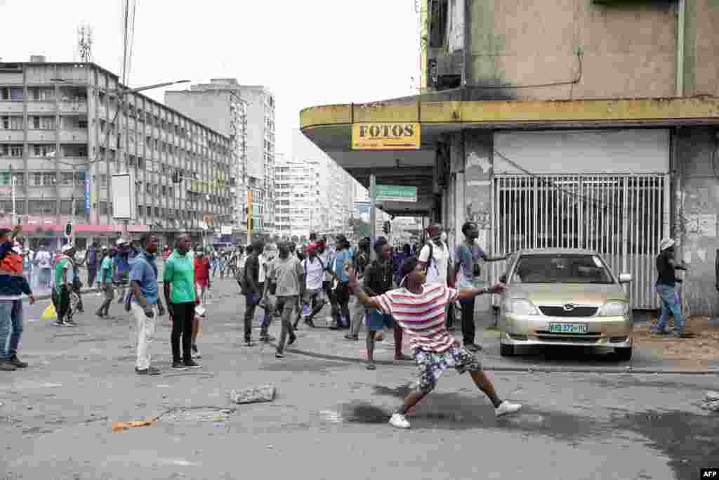 Manifestantes atiram pedras durante confronto com a polícia de choque moçambicana em Maputo em 27 de novembro de 2024