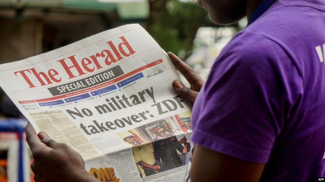 A man reads the front page of a special edition of The Herald newspaper about the crisis in Zimbabwe with the headline 'No military takeover - ZDF' on Nov. 15, 2017 in Harare.