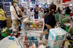 Un carrito de compras está lleno de víveres en un supermercado durante el brote del coronavirus.