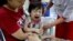 FILE - A child reacts after receiving a measles-rubella vaccination in Yangon, Myanmar, Nov. 26, 2019. 