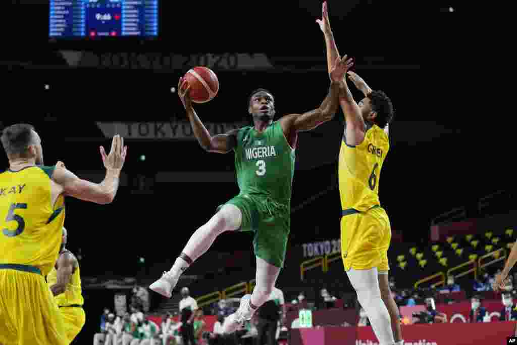 Nigeria&#39;s Caleb Agada (3) drives to the basket against Australia&#39;s Josh Green (6) during a men&#39;s basketball preliminary round game at the 2020 Summer Olympics, Sunday, July 25, 2021, in Saitama, Japan. (AP Photo/Eric Gay)