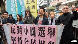 Aktivis Raphael Wong (tiga dari kanan) dari Liga Sosial Demokratik dan peserta unjuk rasa Gerakan Payung Shiu Ka-chun (kanan) bergabung bersama para demonstran lainnya menuju lokasi pemilihan Eksekutif Hong Kong, 26 Maret 2017 (Foto: AFP).