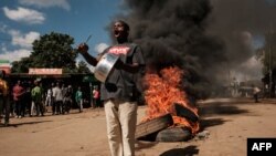 FILE - A protester shows an empty pot on the street during a mass rally called by the opposition leader Raila Odinga who claims the last Kenyan presidential election was stolen from him and blames the government for the hike of living costs in Kibera, Na