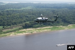 Marine One, yang membawa Presiden Amerika Serikat Joe Biden, terbang di atas Sungai Amazon selama tur udara selama kunjungannya ke Manaus, Brazil, 17 November 2024, sebelum menuju Rio de Janeiro untuk menghadiri KTT G20. (SAUL LOEB / AFP)