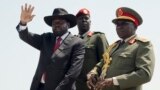 FILE - South Sudan's President Salva Kiir, left, accompanied by army chief of staff Paul Malong, right, waves during an independence day ceremony in the capital Juba, July 9, 2015.