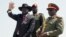 FILE - South Sudan's President Salva Kiir, left, accompanied by army chief of staff Paul Malong, right, waves during an independence day ceremony in the capital Juba, July 9, 2015.