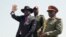 FILE - South Sudan's President Salva Kiir, left, accompanied by army chief of staff Paul Malong, right, waves during an independence day ceremony in the capital Juba, South Sudan.