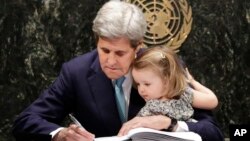 El secretario John Kerry acompañado de su nieta firma el histórico acuerdo sobre cambio climático en la sede de Naciones Unidas.