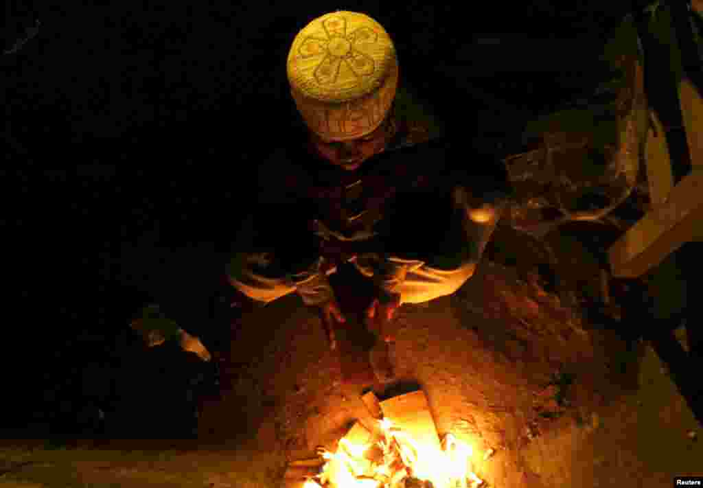 A Pakistani child burns trash to keep himself warm on Saddar Road in Peshawar.