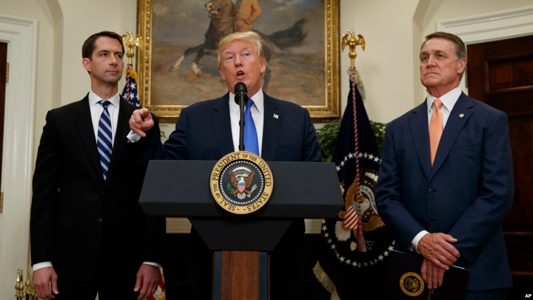 Presiden AS Donald Trump, didampingi Senator Tom Cotton (kiri) dan Senator David Perdue mengumumkan kebijakan baru mengenai imigran legal di Gedung Putih, Rabu (2/8). 