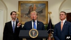 President Donald Trump, flanked by Sen. Tom Cotton, R- Ark., left, and Sen. David Perdue, R-Ga., speaks in the Roosevelt Room of the White House in Washington on Wednesday to introduce a bill that would place new limits on legal immigration. (AP Photo/Evan Vucci)